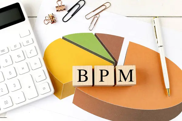 stock image BPM word on wooden block on a chart background . 