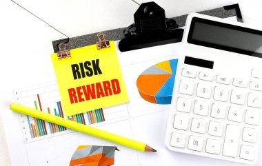 Hesap makinesi, kalem ve grafiği olan sarı bir yapışkan üzerinde RISK REWARD metin . 