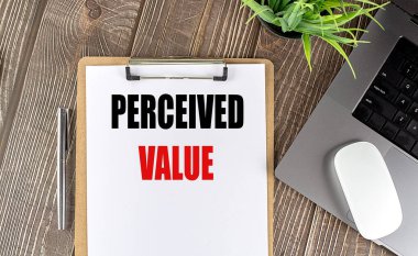 PERCEIVED VALUE text on a clipboard paper with laptop, mouse and pen .  clipart