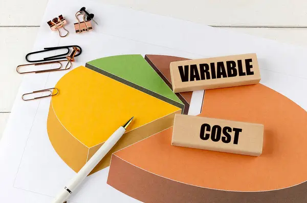 stock image VARIABLE COST word on a wooden block on chart background . 