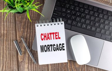 CHATTEL MORTGAGE text on notebook with laptop, mouse and pen . .  clipart