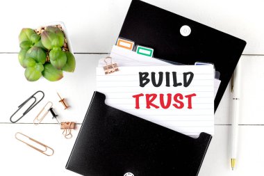 BUILD TRUST text on a note with office supplies .  clipart