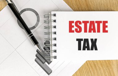 ESTATE TAX text on notebook with chart on a wooden background.  clipart