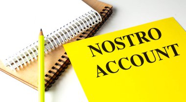 Nostro hesabı olan sarı defter, sarmal defterlerin ve masanın üzerindeki sarı kalemin yanında. .