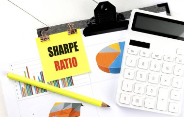 Sharpe ratio concept with sticky note, charts, calculator, and pencil on desk.  clipart