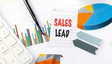 Masasında not, çizelge, hesap makinesi ve ofis malzemeleri bulunan satış başlığı konsepti. 