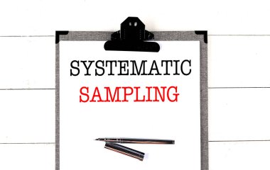 Systematic sampling concept with clipboard and pen on a white wooden background .  clipart