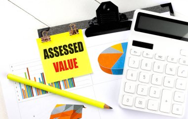 Finansal tablolarıyla ve hesap makinesiyle birlikte yapışkan nota yazılmış değer . 