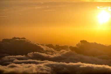 Altın gün doğumu yumuşak bulutların üzerine ışık saçıyor, sakin atmosferli ılık ve huzurlu bir gökyüzü yaratıyor. . 