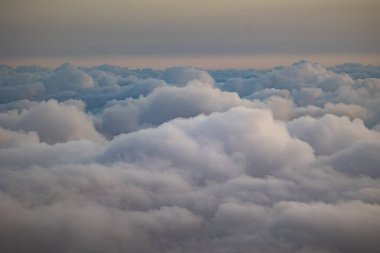 Gün batımında yumuşak, tüylü bulutların engin genişliği, gökyüzünde yumuşak pastel renkler, huzurlu ve rüya gibi bir atmosfer yaratır. . 