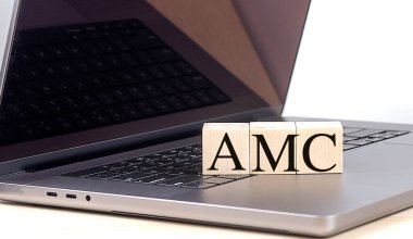 Klavyesinde AMC harfleri olan tahta bloklar, varlık yönetimi şirketi kavramı . 