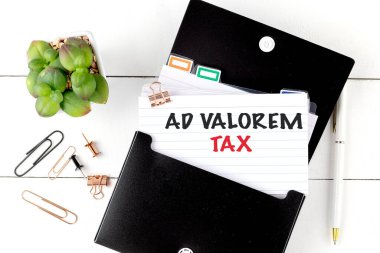 Ofis malzemeleriyle birlikte siyah klasördeki metin ad valorem vergisiyle birlikte indeks kartı ve bitki örtüsü. .