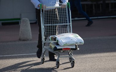 Bialystok, Poland- 27 Mayıs 2025: Alışveriş arabası yüklenen adam, mağaza girişinin yanındaki asfaltta bahçe çantalarıyla dolu.. 