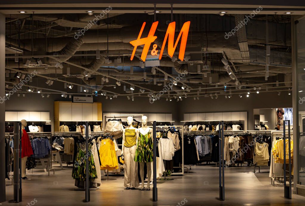 Bialystok,Poland- May 27 ,2025: H and M clothing store entrance with mannequins in a summer outfits and illuminated logo above.