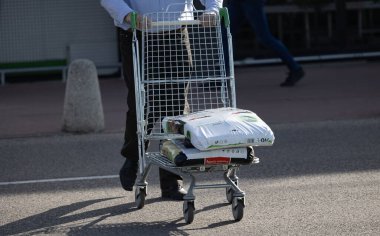 Bialystok, Poland- 27 Mayıs 2025: Alışveriş arabası yüklenen adam, mağaza girişinin yanındaki asfaltta bahçe çantalarıyla dolu.. 