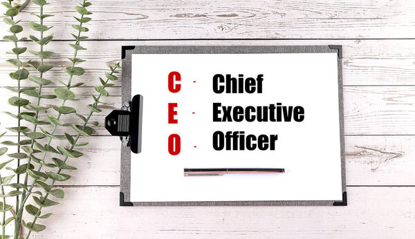 Акроним CEO написан на планшете со значениями руководитель, исполнительный директор, офицер на белом деревянном фоне. 