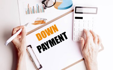 Çizelgeler, hesap makinesi, gözlük ve kalem tutan ellerle birlikte bir masanın üzerinde metin kaparosu olan pano . 