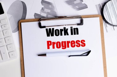 Sözcüklerin çalıştığını gösteren bir pano, kalem, hesap makinesi ve grafiklerle birlikte., . 