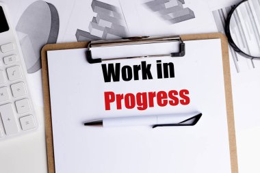 Sözcüklerin çalıştığını gösteren bir pano, kalem, hesap makinesi ve grafiklerle birlikte., . 