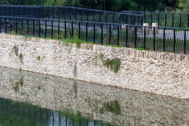 Nehrin kıyısında çit var.