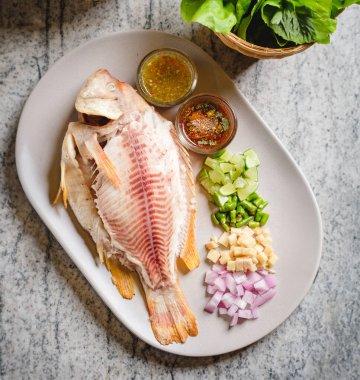 Yapraklara sarılmış yiyecek ve ızgara yakut balığı..