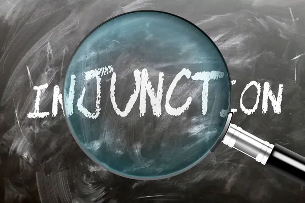 Stock image Injunction - learn, study and inspect it. Taking a closer look at injunction. A magnifying glass enlarging word 'injunction' written on a blackboard