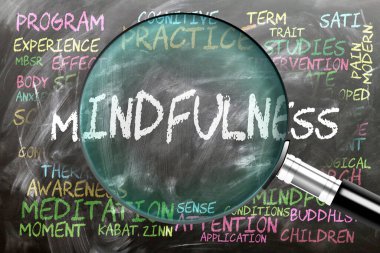 Farkındalık inceleniyor, yakından inceleniyor. En önemli konular ve fikirler bir büyüteç tarafından incelenen bir karatahtaya yazılan farkındalıkla ilgilidir..