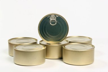 Beyaz ve gri arka planda birçok kapalı teneke kutu var. Balık ve et ürünleri için metal kutular