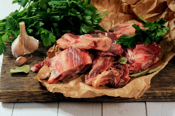 stock image Beef bone selection for soup. Fresh pieces of meat with bones with spices, parsley and bay leaves on a white background