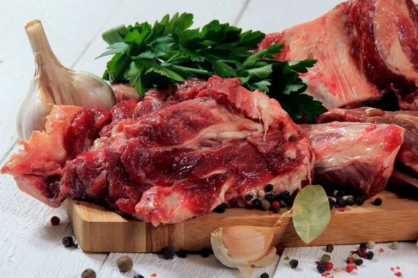 スープ用の牛骨選択 白い背景にスパイス パセリとベイリーフと骨と肉の新鮮な作品 — ストック写真