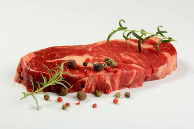 Beyaz arka planda taze çiğ biftek, baharatlı çiğ biftek.