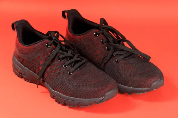 Kırmızı Arka Planda Siyah Kırmızı Spor Ayakkabı Teması Bir Çift — Stok fotoğraf