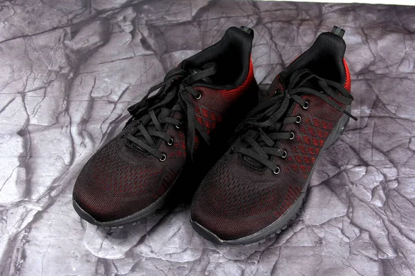 Siyah Kırmızı Spor Ayakkabıları Siyah Taş Arka Planda — Stok fotoğraf