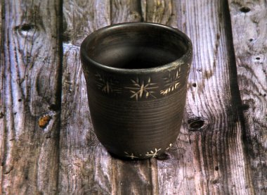 Tahta bir arka planda kara toprak eşyalar, el yapımı kil kaplar.