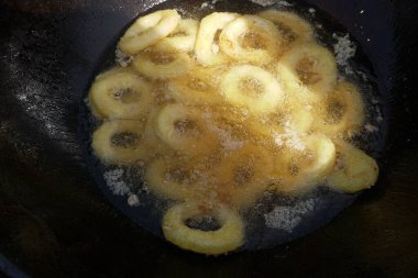   Tavada kızaran kalamar halkaları. Kızarmış soğan halkalarını kızgın yağda kızartma makinesinde yakın..                             