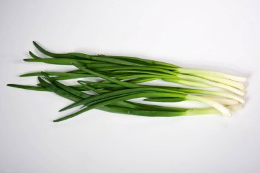 Taze soğan yeşili yaprak beyaz üzerine yakın çekim, bir demet yeşil soğan