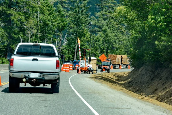 stock image Cameron Bluffs, Vancouver Island, British Columbia, Canada: June 29, 2023: Single lane traffic on highway 4 waits to move past the Cameron Bluffs following a wildfire on Vancouver Island.