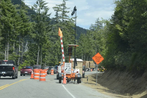 stock image Cameron Bluffs, Vancouver Island, British Columbia, Canada: June 29, 2023: Single lane traffic on highway 4 waits to move past the Cameron Bluffs following a wildfire on Vancouver Island.