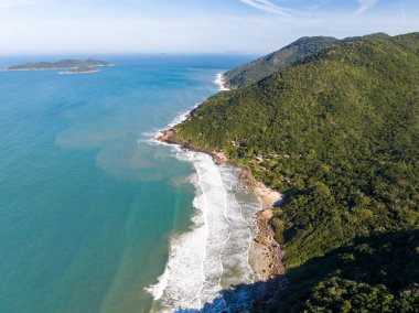 Sahili, dağları ve Brezilya 'da dalgaları olan mavi okyanusu olan bir sahil. Saquinho sahilinin havadan görünüşü. Florianopolis Santa Catarina. SC