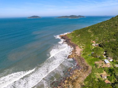 Sahili, dağları ve Brezilya 'da dalgaları olan mavi okyanusu olan bir sahil. Saquinho sahilinin havadan görünüşü. Florianopolis Santa Catarina. SC