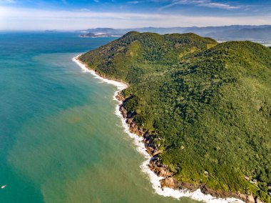 Sahili, dağları ve Brezilya 'da dalgaları olan mavi okyanusu olan bir sahil. Saquinho sahilinin havadan görünüşü. Florianopolis Santa Catarina. SC