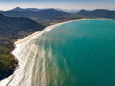 Sahili, dağları ve Brezilya 'da dalgaları olan mavi okyanusu olan bir sahil. Saquinho sahilinin havadan görünüşü. Florianopolis Santa Catarina. SC