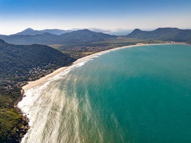 Sahili, dağları ve Brezilya 'da dalgaları olan mavi okyanusu olan bir sahil. Saquinho sahilinin havadan görünüşü. Florianopolis Santa Catarina. SC