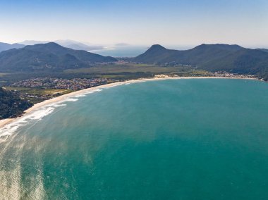 Sahili, dağları ve Brezilya 'da dalgaları olan mavi okyanusu olan bir sahil. Saquinho sahilinin havadan görünüşü. Florianopolis Santa Catarina. SC
