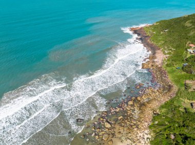 Sahili, dağları ve Brezilya 'da dalgaları olan mavi okyanusu olan bir sahil. Saquinho sahilinin havadan görünüşü. Florianopolis Santa Catarina. SC