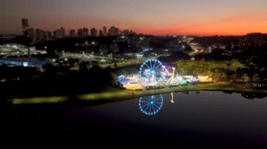 Curitiba Parana, Brezilya 'da. Hava görüntüsü. Binalar ve Tangua Park manzaralı harika bir gün batımı. Yansımalı göl.