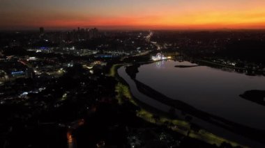 Curitiba Parana, Brezilya 'da. Hava görüntüsü. Binalar ve Tangua Park manzaralı harika bir gün batımı. Yansımalı göl.