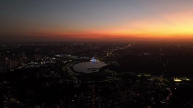 Curitiba Parana, Brezilya 'da. Hava görüntüsü. Binalar ve Tangua Park manzaralı harika bir gün batımı. Yansımalı göl.
