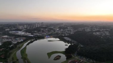 Curitiba Parana, Brezilya 'da. Hava görüntüsü. Binalar ve Tangua Park manzaralı harika bir gün batımı. Yansımalı göl.