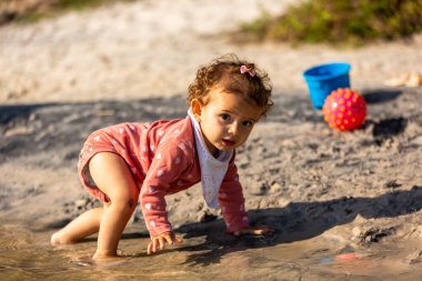 Genç beyaz bir aile güneşli bir öğleden sonra gölde piknik yapıyor..